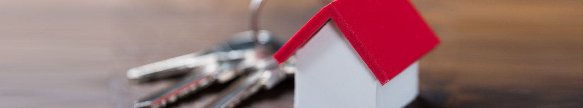 Miniature house and house keys used as a banner for Residential Real Estate