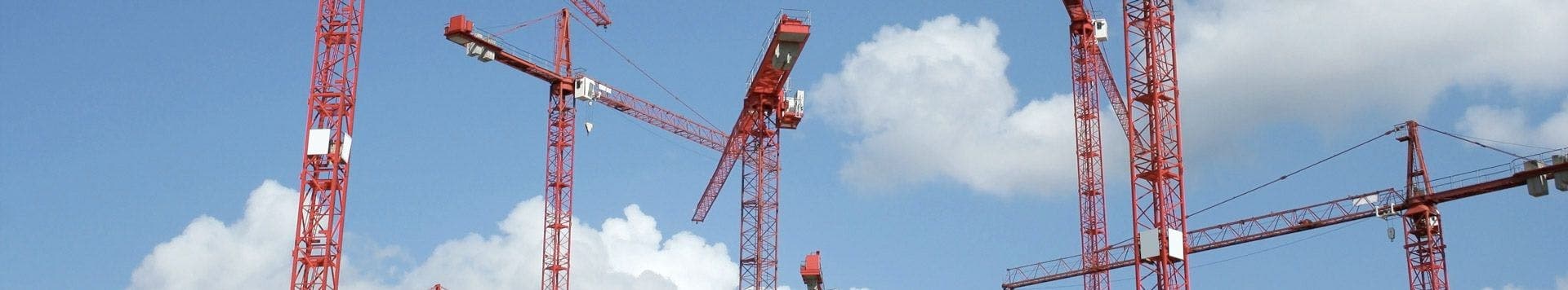 Red cranes against a blue sky used as a banner of real estate commercial
